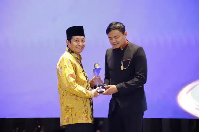 
Menag Nasaruddin Umar menerima penghargaan di bidang keterbukaan informasi dari Wakil Ketua KIP, Arya Sandhiyudha dalam Anugerah Keterbukaan Informasi Publik 2024 di Jakarta, Selasa (17/12/2024).